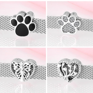 Macro shot of S925 silver charm collection featuring cat paw and tree of life heart designs