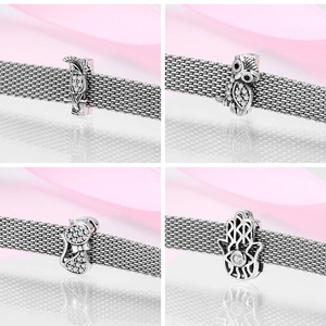 Detail view of S925 sterling silver charms featuring owl and cat on mesh bracelet