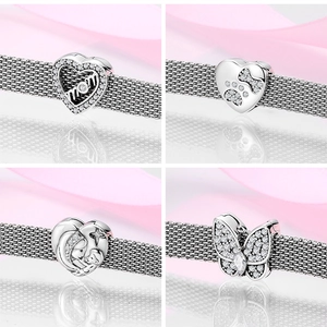 Macro detail of S925 sterling silver heart and animal charms on mesh bracelet