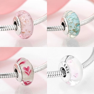 Macro shot of S925 silver core glass beads with floral and heart patterns for bracelets