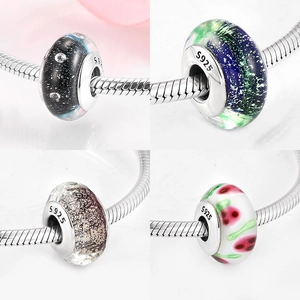 Macro detail of S925 silver glass beads with star and floral patterns for DIY jewelry