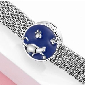 Dettaglio del bracciale a maglia argentata con ciondolo a gatto in smalto blu scuro