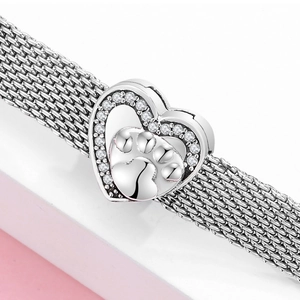 Dettaglio del bracciale a maglia argento con ciondolo cuore zampa e zirconi incastonati