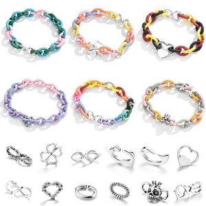 Colorful matte rubber chain link bracelets with silver charms on a white background
