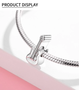 Macro-opname van een gepolijste S925 sterling zilveren gitaarbedel op een ketting