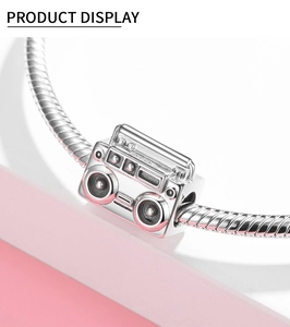 Detalle macro del dije de radio vintage en plata de ley S925 para pulseras