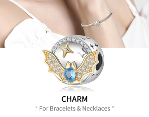 Macro detail of bat wing charm with blue heart gemstone and sparkling white zircons