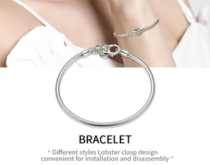 Detail of silver snake chain bracelet with golden accented lobster clasp design