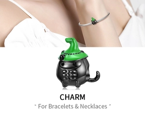 Macro detail of Halloween charm featuring green wizard hat and black cauldron on silver base
