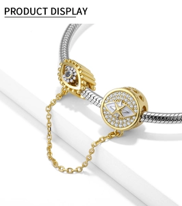 Detalle de dijes de ojo turco y estrella con cadena de seguridad en pulsera de plata