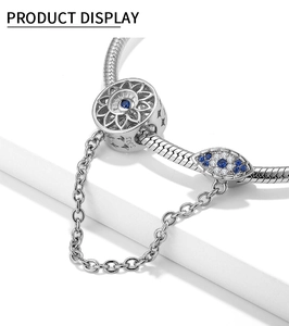 Detail van 925 sterling zilveren boze oog en zonnebloem bedeltjes op een slangenarmband