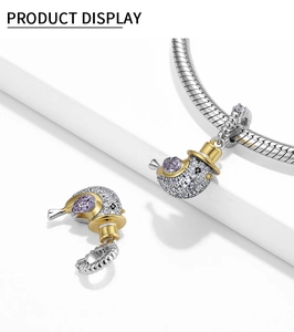 Detail von S925 Silber Vogel-Charm mit lila Edelsteinen und goldenem Hut auf Armband