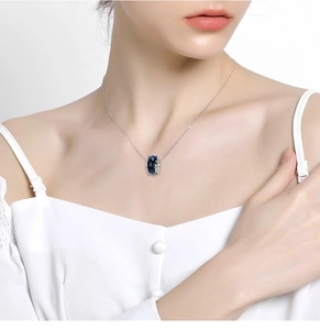 Close-up of elegant blue star glass charm necklace on female model neck in white dress