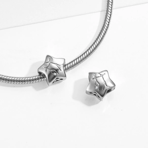 Macro shot of S925 sterling silver Gemini star charm on snake chain bracelet