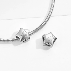 Macro detail of S925 sterling silver zodiac star charms on a snake chain bracelet