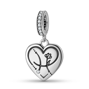 Close-up of S925 sterling silver heart charm with cubic zirconia and floral engravings