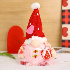 Illuminated Valentine's Day Gnome with knitted hat and red gift box on a wooden background