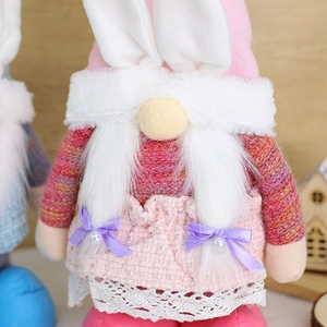Nahaufnahme der rosa Ostergnom-Plüschfigur mit Hasenohren, Strickpullover und Spitzenkleid