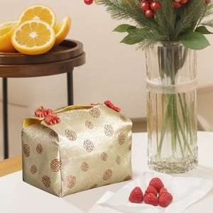 Detail einer traditionellen chinesischen Brokat-Geschenktüte mit goldener Stickerei