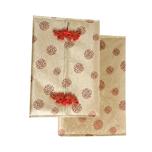 Close-up of champagne gold brocade tissue cover with handmade red knot buttons