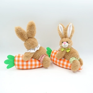 Close-up of Easter plush bunnies sitting on carrot bases with lace and polka dot bow ties