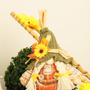 Close-up of harvest gnome with sunflower hat, plaid overalls and straw accents