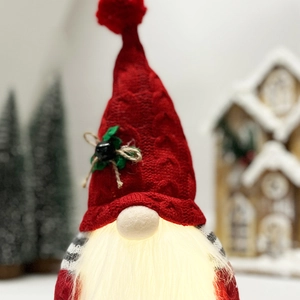 Close-up of a lit Christmas gnome with a red heart-patterned knitted hat and warm LED beard