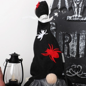 Gnomo di Halloween con cappello a ragno vicino a una tomba RIP e una lanterna