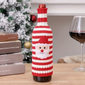 Detail of red and white striped knitted wine bottle cover with a Santa Claus patch ornament