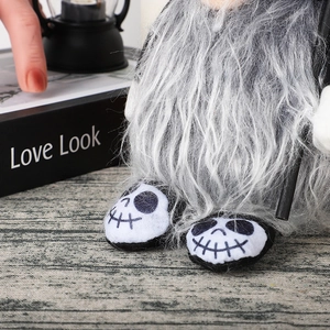 Dettaglio di gnomo di Halloween in peluche con scarpe stampate a scheletro e barba grigia