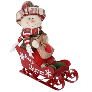 Detail of fabric snowman with plaid hat on a red metal Merry Christmas sleigh