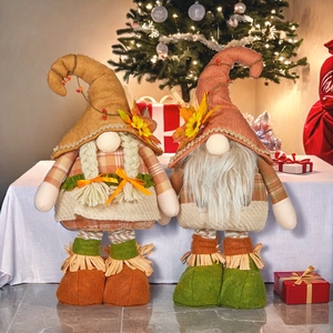 Close-up of autumn gnomes with maple leaves and sunflowers on festive harvest decorations