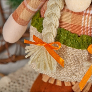 Close-up of autumn gnome detail featuring plaid fabric and orange satin bow decoration