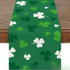 Green St. Patrick's Day table runner with shamrock prints on dark wood surface