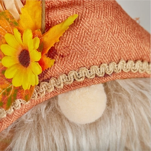 Detailed macro view of the orange herringbone fabric hat and yellow sunflower gnome accessory