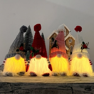 Set of four lighted Christmas gnomes with warm LED glow and knitted berry hats
