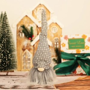 Gnome de Noël suspendu avec bonnet à carreaux gris et longue barbe sur fond de fête