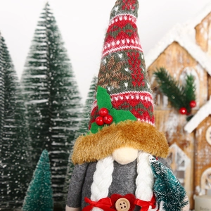 Détail de la figurine de gnome de Noël avec tresses blanches et motifs festifs