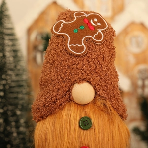 Christmas gnome ornament with gingerbread man hat and orange beard on warm cozy background