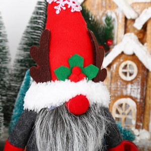 Detail of a Christmas gnome with red snowflake hat and brown reindeer antlers decor