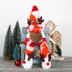 Christmas gnome doll with long legs, reindeer antlers and sequined hat on a wooden bench