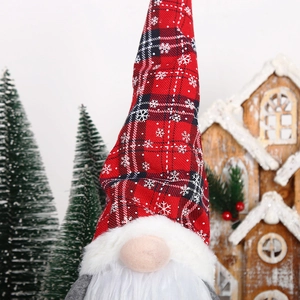 Macro detail of Christmas gnome with red plaid hat and white beard in festive setting