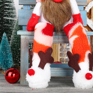 Christmas Gnome doll with long legs and reindeer antler shoes on a festive blue bench