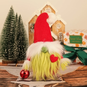Detailed view of a Christmas gnome with green beard holding a red decorative ball ornament