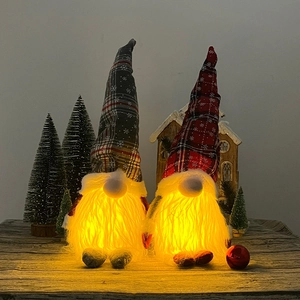 Close-up of glowing LED Christmas gnomes with snowflake patterns and white beards