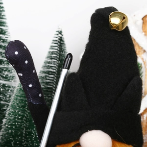 Primer plano de un gnomo navideño con campana dorada y barba de fibras naranjas