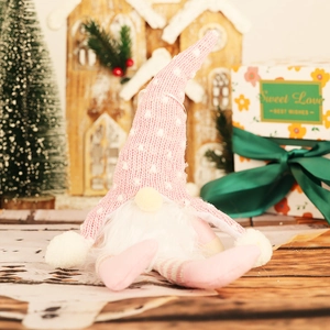 Pink knitted Christmas gnome with glowing lights and long dangling legs for festive decor