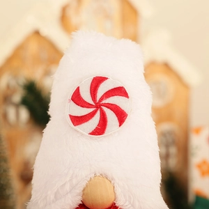 Détail d'un gnome de Noël en peluche blanche avec un patch brodé de sucre d'orge