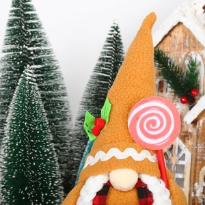 Detail of Christmas gingerbread gnome with tall hat holding a pink candy cane