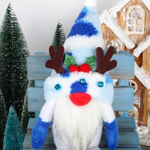 Detail of Christmas gnome plush with blue reindeer antlers on a festive wooden bench